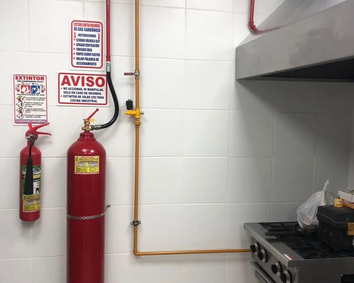 Sistema CO₂ en cocina con extintor portátil PQS